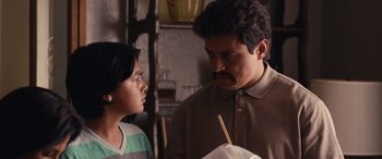 Movie still from “Flamin' Hot” (2023), directed by Eva Longoria – A man and a boy are looking at each other with chopsticks in their hands; Close Up shot, Over the shoulder angle