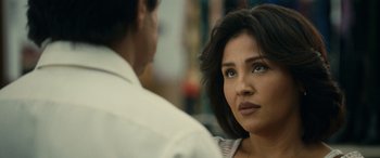 Movie still from “Flamin' Hot” (2023), directed by Eva Longoria – A person sitting on a chair; Close Up shot, Over the shoulder angle