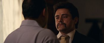 Movie still from “Flamin' Hot” (2023), directed by Eva Longoria – A person wearing a suit and tie; Close Up shot, Over the shoulder angle