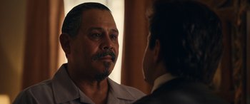 Movie still from “Flamin' Hot” (2023), directed by Eva Longoria – A man with a beard and mustache talking to another man in a suit; Close Up shot, Over the shoulder angle