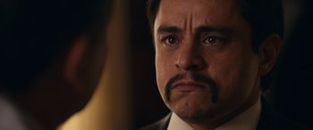 Movie still from “Flamin' Hot” (2023), directed by Eva Longoria – A person wearing a suit and mustache; Close Up shot, Over the shoulder angle