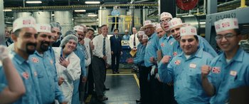 Movie still from “Flamin' Hot” (2023), directed by Eva Longoria – A group of men standing next to each other in a factory; Wide shot, Low angle