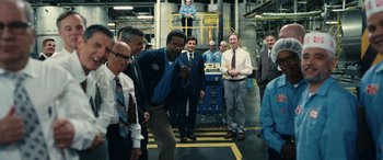 Movie still from “Flamin' Hot” (2023), directed by Eva Longoria – A group of men standing around a factory; Wide shot, Over the shoulder angle