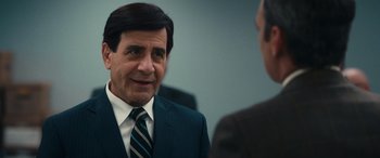 Movie still from “Flamin' Hot” (2023), directed by Eva Longoria – A man wearing a suit and tie talking to another man; Close Up shot, Over the shoulder angle