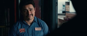 Movie still from “Flamin' Hot” (2023), directed by Eva Longoria – A man with a mustache wearing a blue shirt; Close Up shot, Over the shoulder angle