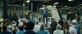 Movie still from “Flamin' Hot” (2023), directed by Eva Longoria – A group of people standing around a factory; Wide shot, Low angle