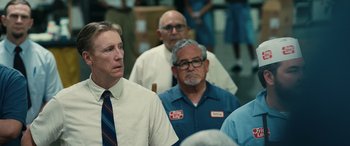 Movie still from “Flamin' Hot” (2023), directed by Eva Longoria – A group of men standing next to each other in a room; Medium shot, Over the shoulder angle