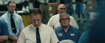 Movie still from “Flamin' Hot” (2023), directed by Eva Longoria – A group of men standing next to each other in a room; Medium shot, Low angle