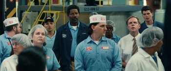Movie still from “Flamin' Hot” (2023), directed by Eva Longoria – A group of people standing in a factory; Medium shot, Over the shoulder angle