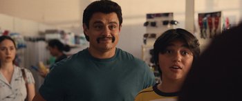 Movie still from “Flamin' Hot” (2023), directed by Eva Longoria – A man and a boy are posing for a picture; Close Up shot, Over the shoulder angle