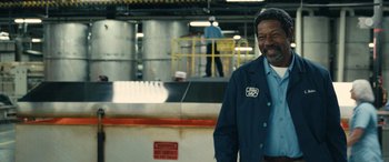 Movie still from “Flamin' Hot” (2023), directed by Eva Longoria – A man standing in front of an industrial building; Medium shot, Low angle