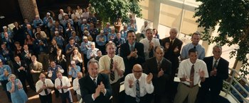Movie still from “Flamin' Hot” (2023), directed by Eva Longoria – A group of men in suits clapping in front of a crowd; Extreme Wide shot, High angle