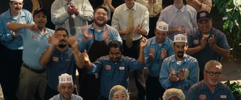 Movie still from “Flamin' Hot” (2023), directed by Eva Longoria – A group of people standing in front of each other clapping; Wide shot, Low angle