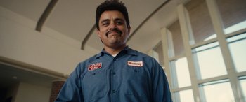 Movie still from “Flamin' Hot” (2023), directed by Eva Longoria – A man with a mustache wearing a blue work shirt; Close Up shot, Low angle