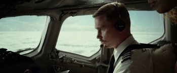 Movie still from “Flight” (2012), directed by Robert Zemeckis – A man wearing a headset looking out the window of an airplane; Close Up shot, Low angle
