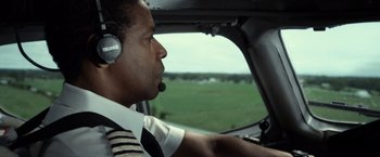 Movie still from “Flight” (2012), directed by Robert Zemeckis – A man in a helicopter with a headset on; Close Up shot, Low angle