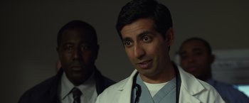 Movie still from “Flight” (2012), directed by Robert Zemeckis – A man in a white lab coat standing next to another man in a suit; Close Up shot, Over the shoulder angle