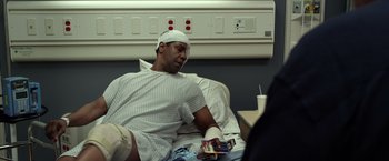 Movie still from “Flight” (2012), directed by Robert Zemeckis – A man with a bandaged head sitting in a hospital bed; Medium shot, High angle