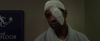 Movie still from “Flight” (2012), directed by Robert Zemeckis – A man with bandages on his head and a towel around his neck; Close Up shot, High angle