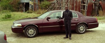 Movie still from “Flight” (2012), directed by Robert Zemeckis – A man standing in front of a red car; Wide shot, Over the shoulder angle