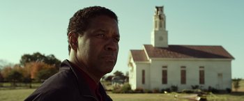 Movie still from “Flight” (2012), directed by Robert Zemeckis – A man standing in front of a church in a field; Close Up shot, Low angle
