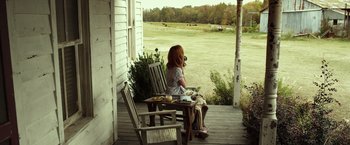 Movie still from “Flight” (2012), directed by Robert Zemeckis – A woman sitting on a bench on a porch; Wide shot, High angle