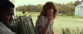 Movie still from “Flight” (2012), directed by Robert Zemeckis – A woman sitting on top of a wooden bench; Medium shot, Low angle