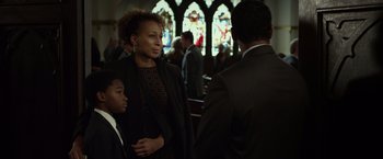 Movie still from “Flight” (2012), directed by Robert Zemeckis – A woman and a boy are standing in front of a man in a suit; Medium shot, Over the shoulder angle