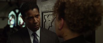 Movie still from “Flight” (2012), directed by Robert Zemeckis – A man in a suit and tie talking to a woman in front of a wall; Close Up shot, Over the shoulder angle