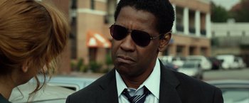 Movie still from “Flight” (2012), directed by Robert Zemeckis – A person wearing a suit and sunglasses; Close Up shot, Low angle