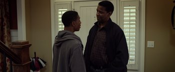 Movie still from “Flight” (2012), directed by Robert Zemeckis – Two men standing next to each other in front of a door; Medium shot, Over the shoulder angle