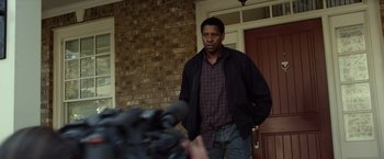 Movie still from “Flight” (2012), directed by Robert Zemeckis – A man standing in front of a brick wall; Medium shot, Over the shoulder angle