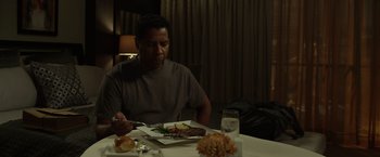 Movie still from “Flight” (2012), directed by Robert Zemeckis – A man sitting at a table with a plate of food in front of him; Medium shot, High angle