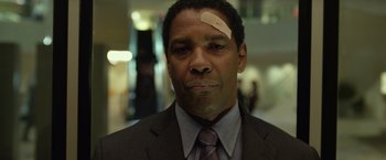 Movie still from “Flight” (2012), directed by Robert Zemeckis – A man in a business suit with a bandage on his forehead; Close Up shot, Low angle