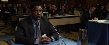 Movie still from “Flight” (2012), directed by Robert Zemeckis – A man sitting in front of a microphone; Close Up shot, Over the shoulder angle