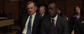 Movie still from “Flight” (2012), directed by Robert Zemeckis – A group of men in suits sitting next to each other in a room; Medium shot, Low angle