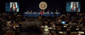 Movie still from “Flight” (2012), directed by Robert Zemeckis – A group of people sitting in front of an audience at a meeting; Extreme Wide shot, Over the shoulder angle