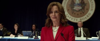 Movie still from “Flight” (2012), directed by Robert Zemeckis – A woman in a red jacket is standing in front of a microphone; Close Up shot, Over the shoulder angle