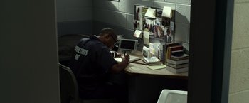 Movie still from “Flight” (2012), directed by Robert Zemeckis – A man sitting at a desk writing on a paper; Medium shot, High angle