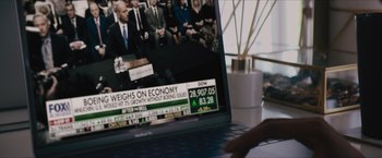 Movie still from “Flight/Risk” (2022), directed by Karim Amer – A computer screen showing a news story about the economy; Extreme Close Up shot, Over the shoulder angle