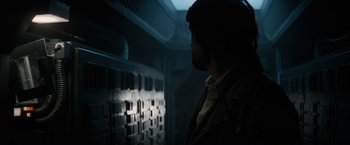 Movie still from “Alien” (1979), directed by Ridley Scott – A man standing next to a wall in a dark room; Close Up shot, Low angle