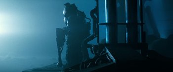 Movie still from “Alien” (1979), directed by Ridley Scott – A man standing next to pipes in a dark room; Wide shot, Low angle