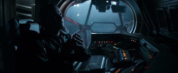 Movie still from “Alien” (1979), directed by Ridley Scott – A man sitting at a table in front of a control panel; Medium shot, High angle