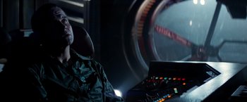 Movie still from “Alien” (1979), directed by Ridley Scott – A person sitting in a chair in a room; Medium shot, Over the shoulder angle