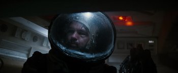 Movie still from “Alien” (1979), directed by Ridley Scott – A man wearing a space helmet in a dark room; Close Up shot, Overhead angle