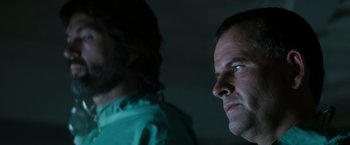 Movie still from “Alien” (1979), directed by Ridley Scott – Two men standing next to each other in the dark; Close Up shot, Low angle