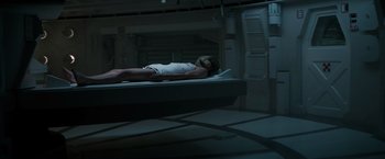 Movie still from “Alien” (1979), directed by Ridley Scott – A woman laying on a bed in a dark room; Wide shot, High angle