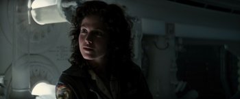 Movie still from “Alien” (1979), directed by Ridley Scott – A woman with curly brown hair is in the dark; Close Up shot, Low angle