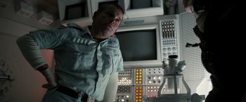 Movie still from “Alien” (1979), directed by Ridley Scott – A man standing in front of a computer screen; Medium shot, Low angle