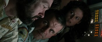 Movie still from “Alien” (1979), directed by Ridley Scott – Two men and a woman looking into each other's eyes; Close Up shot, Low angle